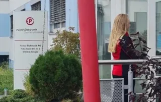 Das Foto zeigt eine Kurierin der KDE Transport GmbH, wie sie gerade bei der Pantel Elektronik eine Sendung anliefert.