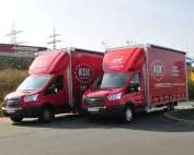 Zwei LKW der KDE Transport GmbH parken nebeneinander. Im Hintergrund sieht man die A3.
