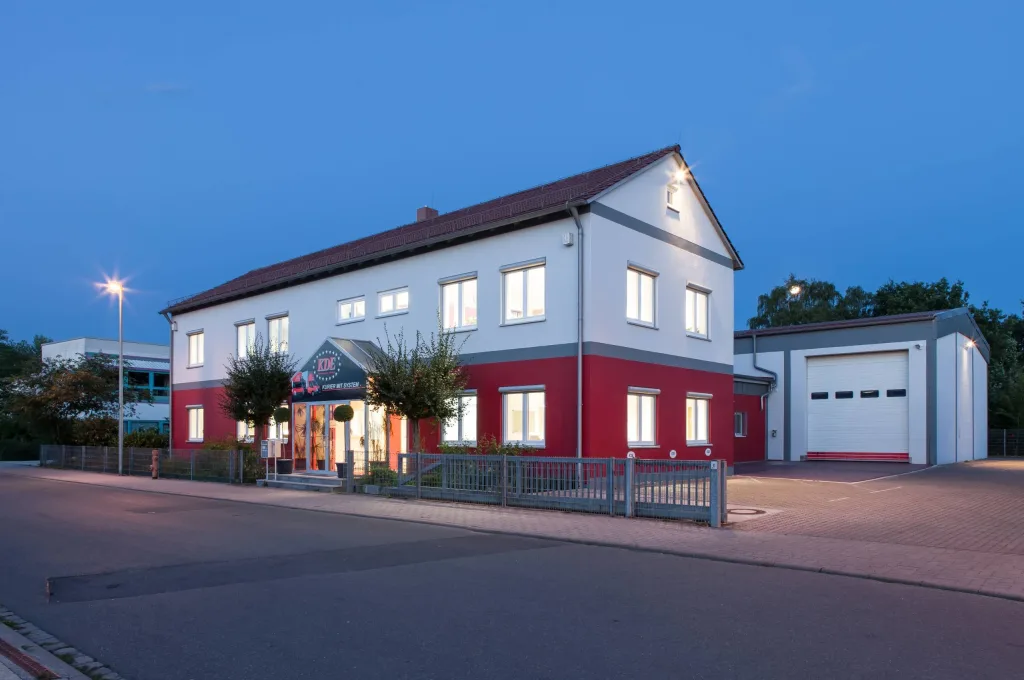 KDE Gebäude Erlangen 2 Das Foto zeigt die KDE-Zentrale Erlangen. Im Vordergrund ist der Bürotrakt, dahinter die Halle für Lagerung und Umschlag.