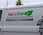 Das E-Fahrzeug der KDE Transport GmbH ist mit dem Fair & Green Logo des Unternehmens beschriftet.