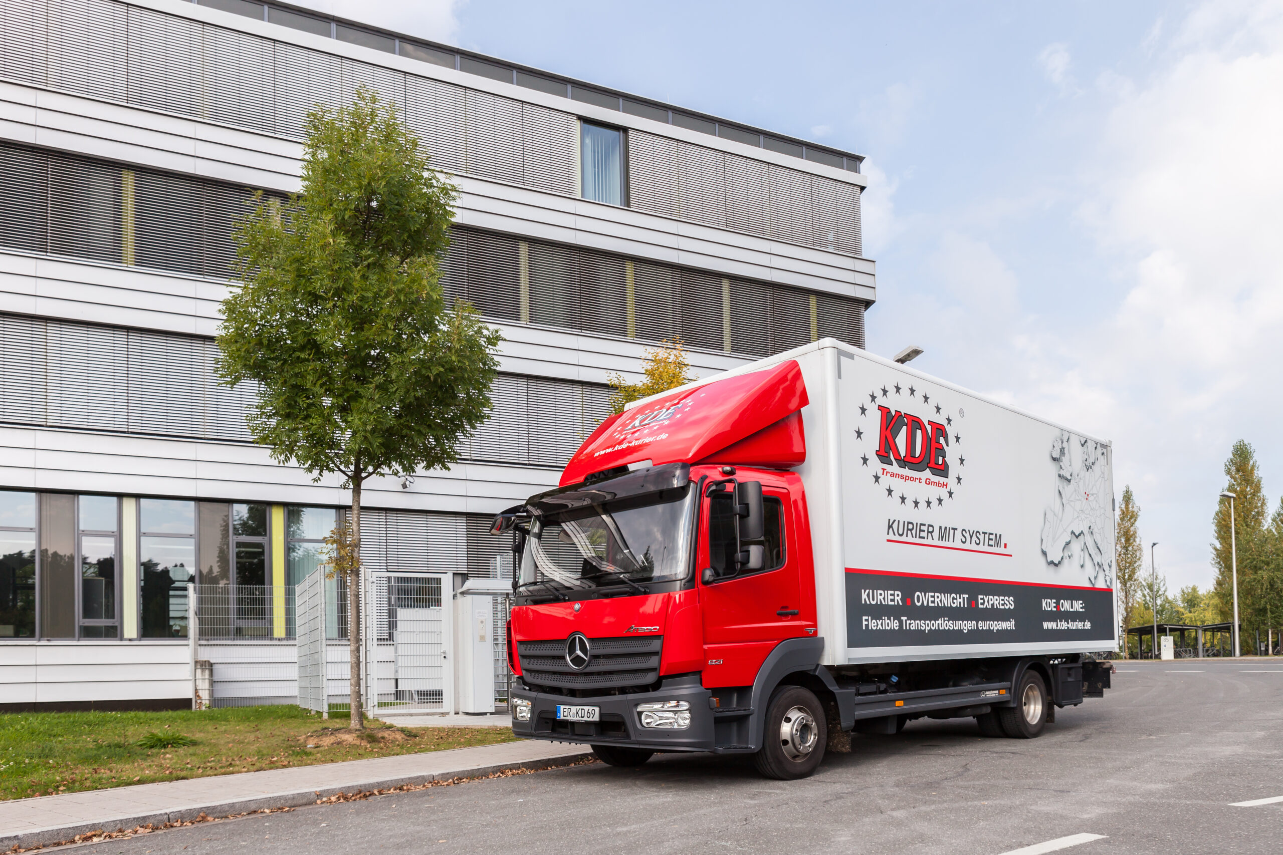 KDE-LKW stehend 1 Ein LKW der KDE Transport GmbH steht beim Kunden vor Ort und wartet auf die Beladung.